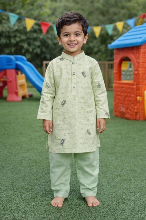 Boy wearing hand & heart™ kids mint green Panjabi and white pajamas, smiling in a playground setting.