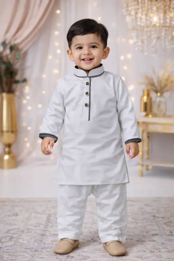 Adorable young boy wearing a white kids kurta set with black contrast trim for special occasions.