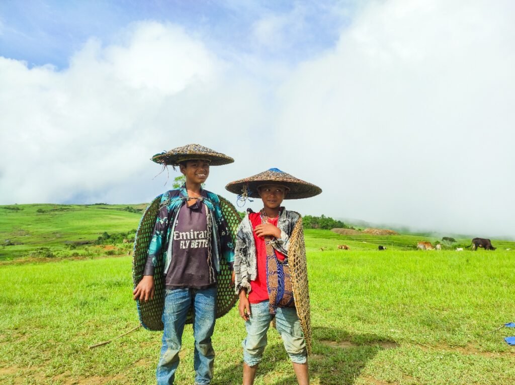 Children standing near cattle in a rural household, highlighting close human–animal interaction in smallholder farming.